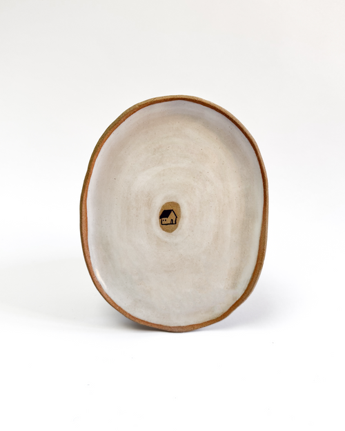 Ceramic plate with a painted house design and white-washed glaze